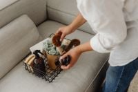 Kaboompics - Woman Organizing a Wire Basket with Home Care Items on a Sofa
