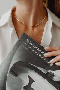 Kaboompics - Gold Necklace and Architecture Book Cover in a Neutral Fashion Close-Up