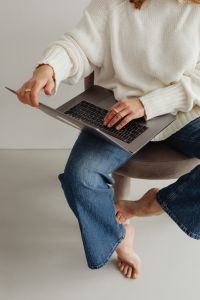 Kaboompics - Faceless Woman in White Sweater Working on Laptop with Stylus