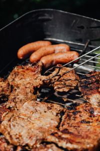 Kaboompics - Vertical Close-Up of Pork Neck Steaks and Sausages on a Garden Barbecue Grill