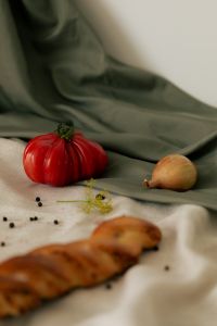 Kaboompics - Red Tomato, Shallots and Bread on Dark Green and Linen Background