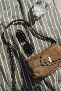 Kaboompics - Brown Leather Bag and Black Sunglasses on a Striped Beach Towel
