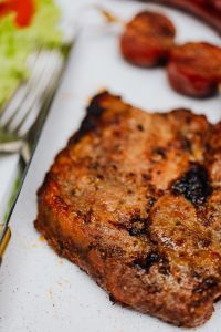 Kaboompics - Portrait White-Plate Barbecue Meal with Grilled Pork Neck, Sausage and Salad