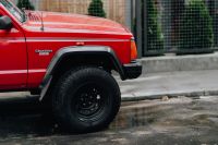 Kaboompics - Red Jeep Cherokee Front Wheel on a Wet City Street