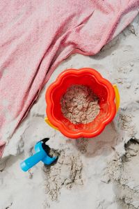 Kaboompics - Sand Bucket and Blue Shovel Beside a Pink Beach Towel for Beach Vacation