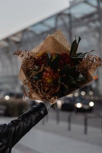 Kaboompics - Wrapped Autumn Bouquet Held Against a Blurred City Background