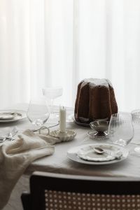 Kaboompics - Minimal White Christmas Dinner Table with Panettone and Glassware