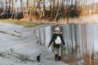 Kaboompics - Woman Walking a Small Dog Along an Icy Lakeside Path in Winter