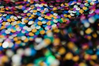Kaboompics - Vibrant Rainbow Sequins in Focus with Blurred Foreground, Colorful Textile Background