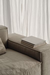 Kaboompics - Closed Laptop and Stacked Books on a Neutral Sofa, Minimal Home Office