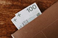 Kaboompics - 100 Polish Zloty Banknotes Peeking from a Linen Wallet on a Wooden Table