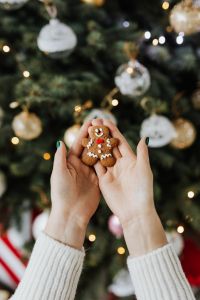 Kaboompics - Gingerbread Cookie Held in Front of Decorated Tree