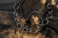 Kaboompics - Chunky Silver Chain and Fine Crystal Necklace on Driftwood