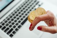 Kaboompics - Close Up of Bitcoin Coin in Hand by Laptop