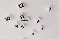 Kaboompics - Close-Up of Minimalist 3D Wall Clock with Floating Black Numbers on White