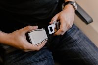 Kaboompics - Close up of man hands fasten belts while sitting on airplane seat