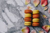 Kaboompics - Macaron Copy Space with Peach Roses and Petals on a Gray Marble Background
