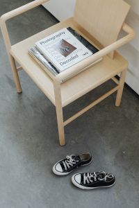 Kaboompics - Wooden Chair with Magazines, Books and Black Canvas Sneakers