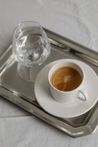 Kaboompics - Coffee Cup and Water Glass on Silver Tray over White Tablecloth