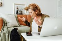 Kaboompics - Woman Gesturing to Her Dog Beside an Open Laptop in the Living Room