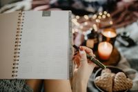 Kaboompics - Writing in a notebook lying in bed, with coffee, candles, and gingerbreads