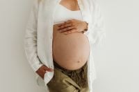 Kaboompics - Pregnant Woman Touching Her Belly in a White Blazer