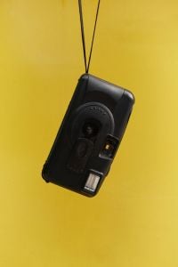 Kaboompics - Close Up Of A Disposable Camera Against Yellow Background