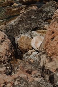 Kaboompics - Shallow Seawater Flowing Around Dark Shoreline Rocks