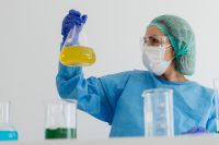Kaboompics - Chemistry Teacher Holding Yellow Solution in Conical Flask