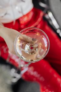Kaboompics - Champagne Toast Detail with Hand and Red Party Suit