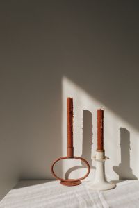 Kaboompics - Sculptural Taper Candle Holders Casting Sunlit Shadows on a Neutral Wall