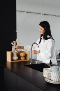 Kaboompics - Woman Touching Dried Flowers in a Kitchen Vase