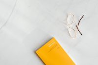 Kaboompics - Orange Book And Eyeglasses Minimal Marble Flat Lay