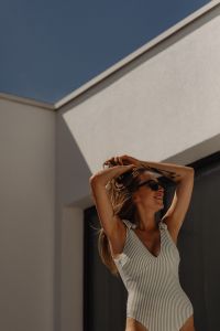 Kaboompics - Smiling Beachwear Model in Sunglasses with Arms Raised