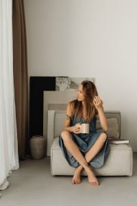 Kaboompics - Woman Taking a Coffee Break in a Denim Dress in a Cozy Living Room
