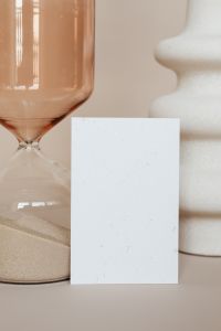 Kaboompics - Close-Up Blank Business Card Beside Amber Hourglass and White Ceramic Vase, Minimal Stationery Mockup