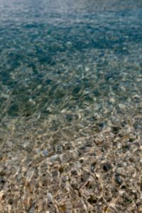 Kaboompics - Clear Turquoise Seawater over Pebbles with Sunlit Ripple Patterns