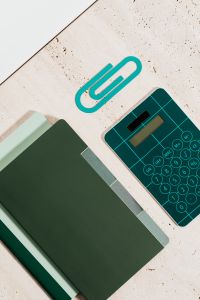 Kaboompics - Green Notebook, Teal Calculator and Paper Clip Flat Lay for Math Homework and Study Planning