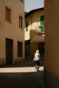 Kaboompics - Woman Walking Through a Sunlit Italian Village Street
