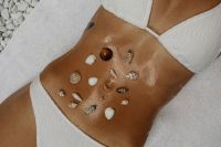 Kaboompics - Seashells Arranged on Sun-Kissed Skin in a White Swimsuit