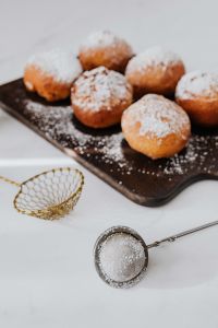 Kaboompics - Vertical Flat Lay of Pączki with Gold Sifter and Skimmer
