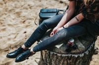 Kaboompics - Woman’s Legs Stretched Across a Beach Stump with Cola Can
