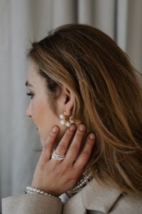 Kaboompics - Woman Touching Her Face to Show Pearl Earrings and Rings