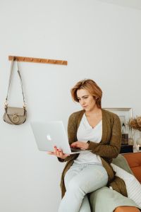 Kaboompics - Woman Working on a Laptop from a Leather Sofa in a Neutral Living Room