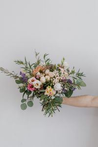 Kaboompics - Vertical Mixed Flower Bouquet Held against a Plain White Background with Copy Space