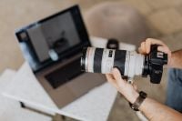 Kaboompics - Photographer's Hands Holding DSLR over MacBook