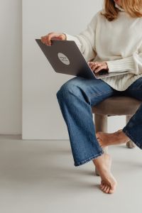 Kaboompics - Faceless Woman in White Sweater Sitting with Laptop
