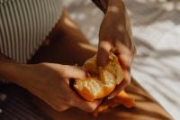 Kaboompics - Hands Peeling a Fresh Orange in a Striped Swimsuit