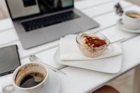 Kaboompics - Cappuccino and Tiramisu Beside a Laptop on a Cafe Table