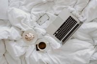 Kaboompics - Macbook, an iPhone, a coffee, a chocolate and a notebook in a bed